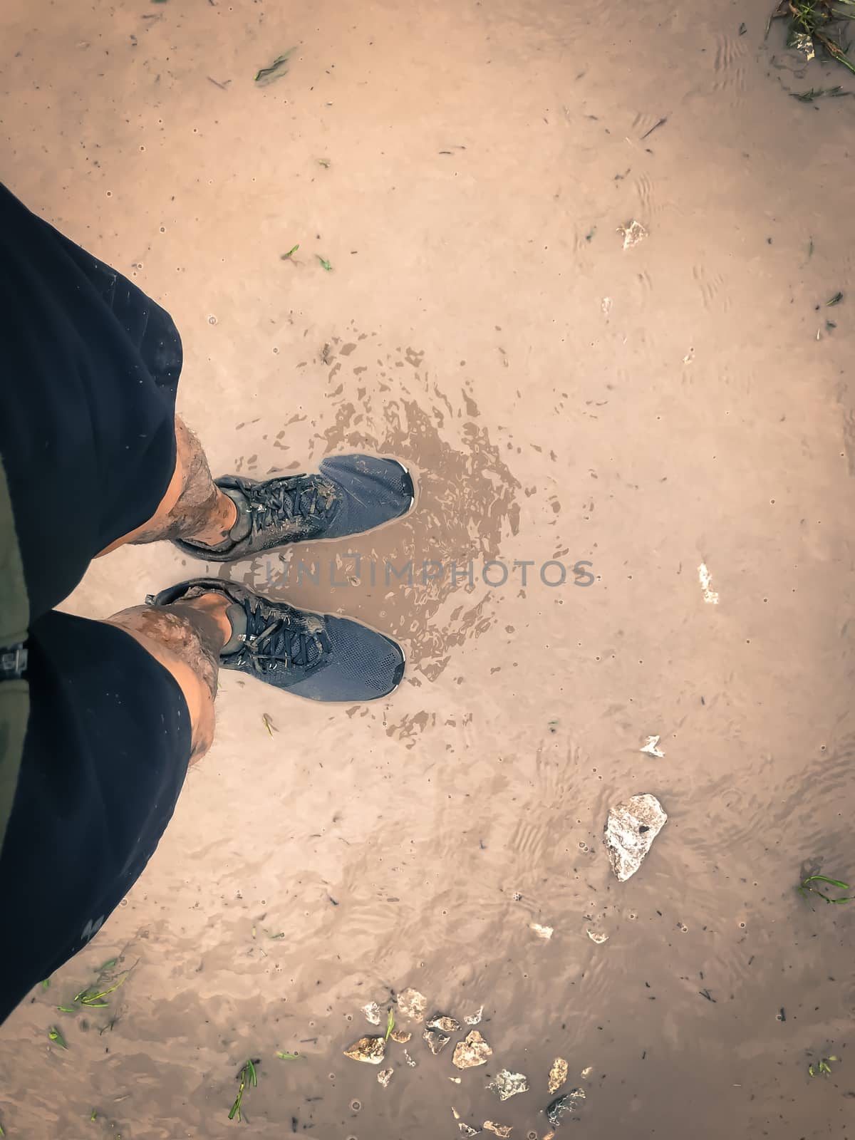 Filtered image top view man wearing sport shoes sneakers on muddy race track by trongnguyen