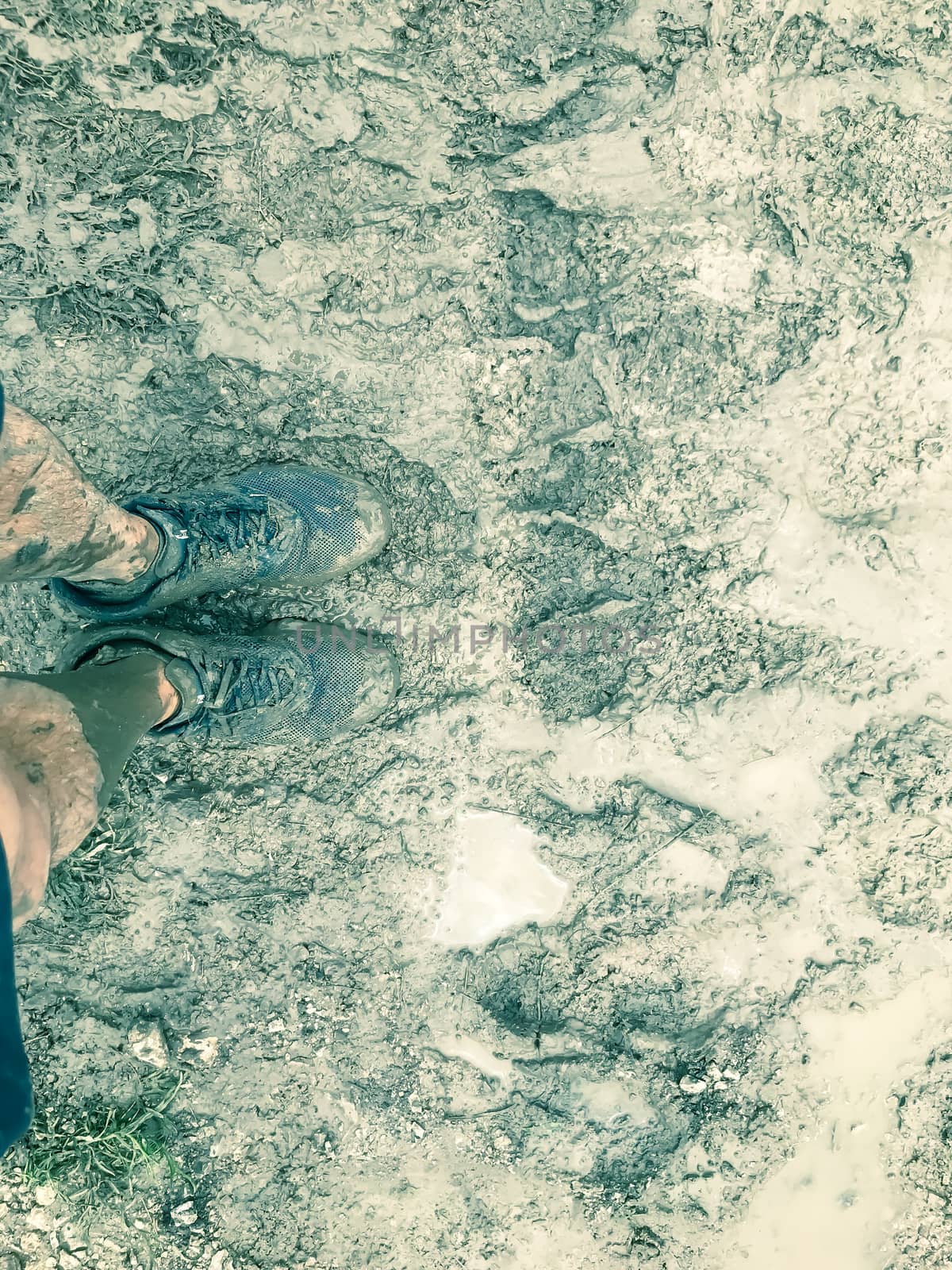 Top view of muddy running shoes on obstacle course racing in America, cross country events