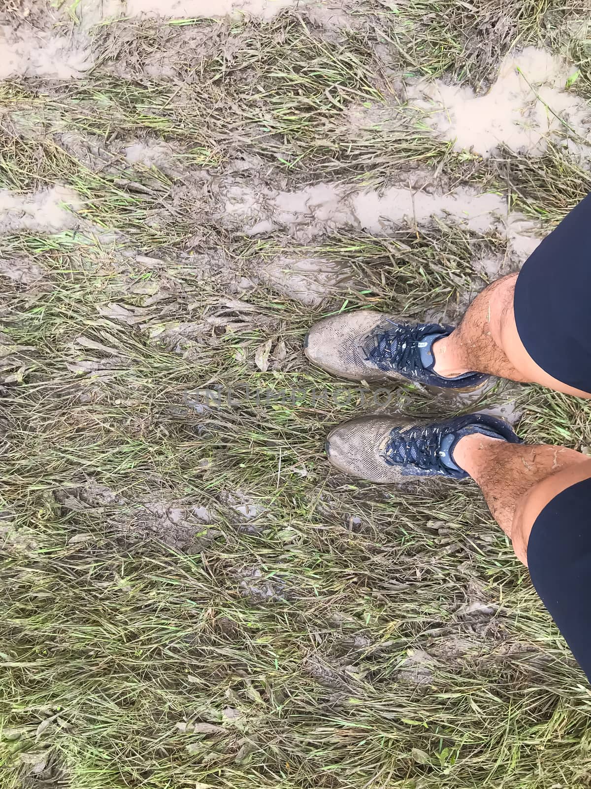 Top view of muddy running shoes on obstacle course racing in America, cross country events