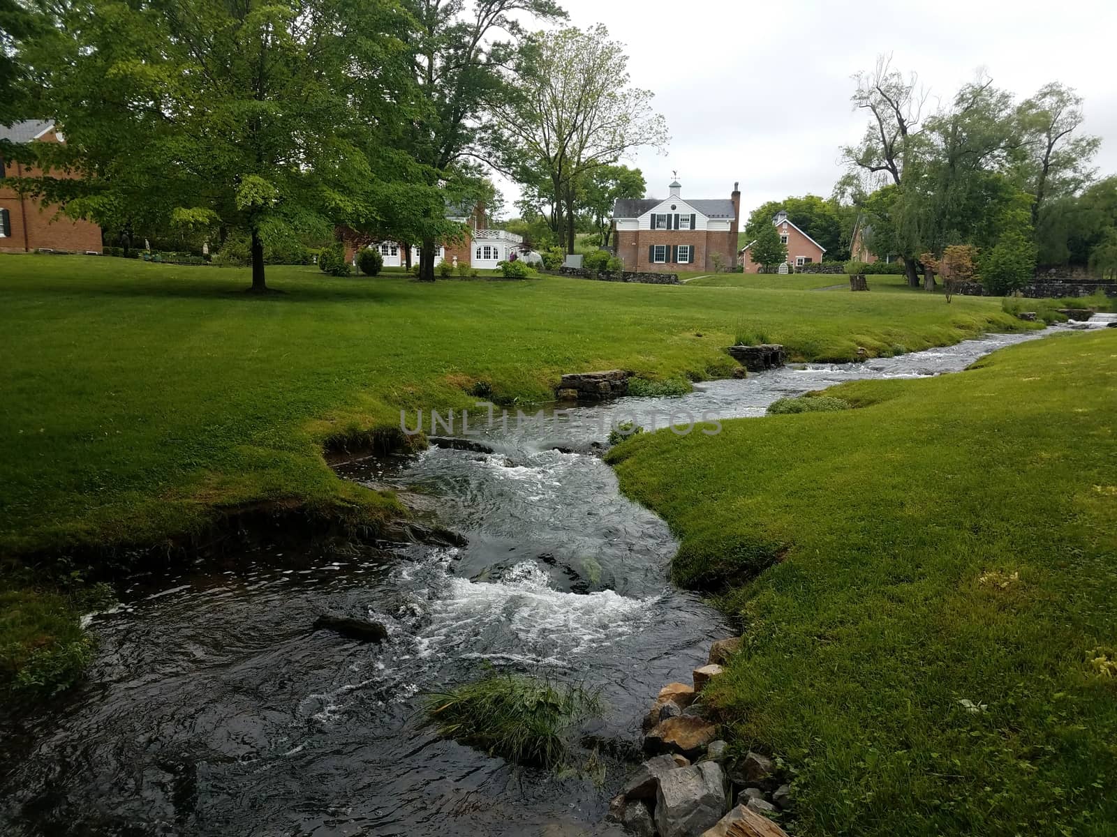 green grass with flowing river or stream or creek by stockphotofan1