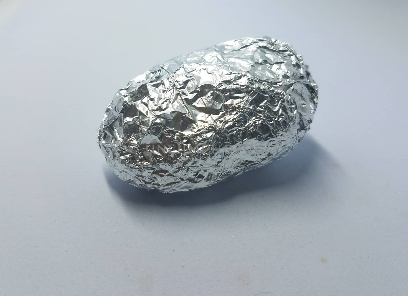 object wrapped in metal foil on white background