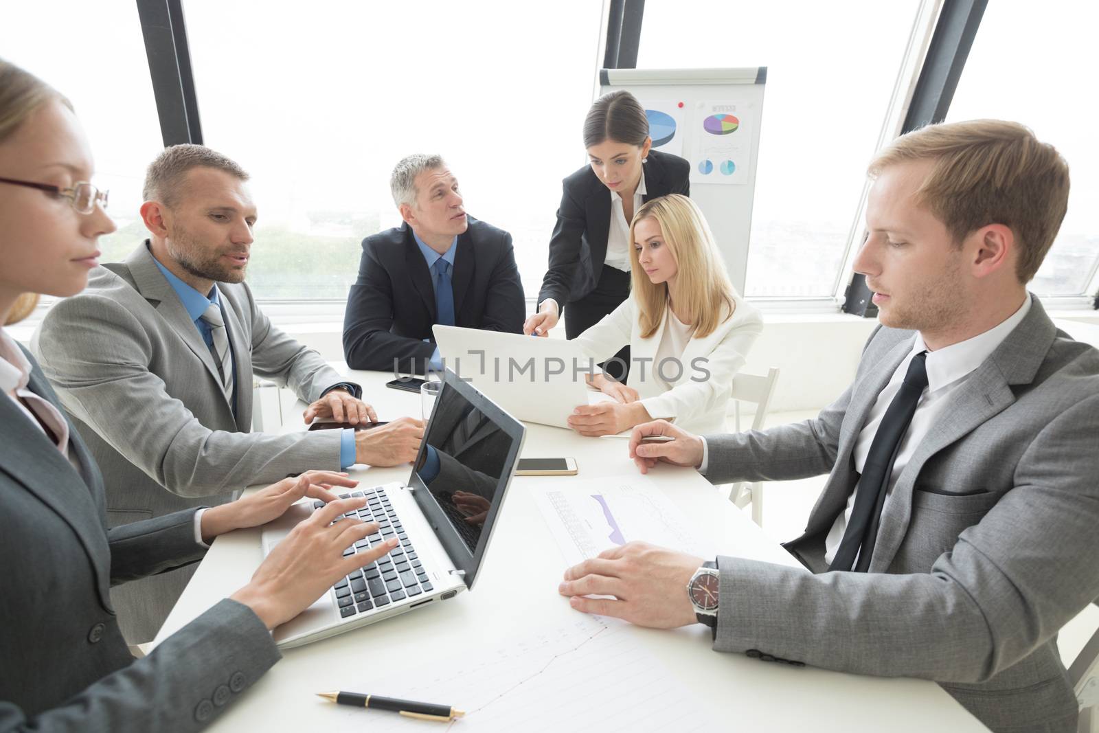 Business people at meeting sitting around office table and discuss documents