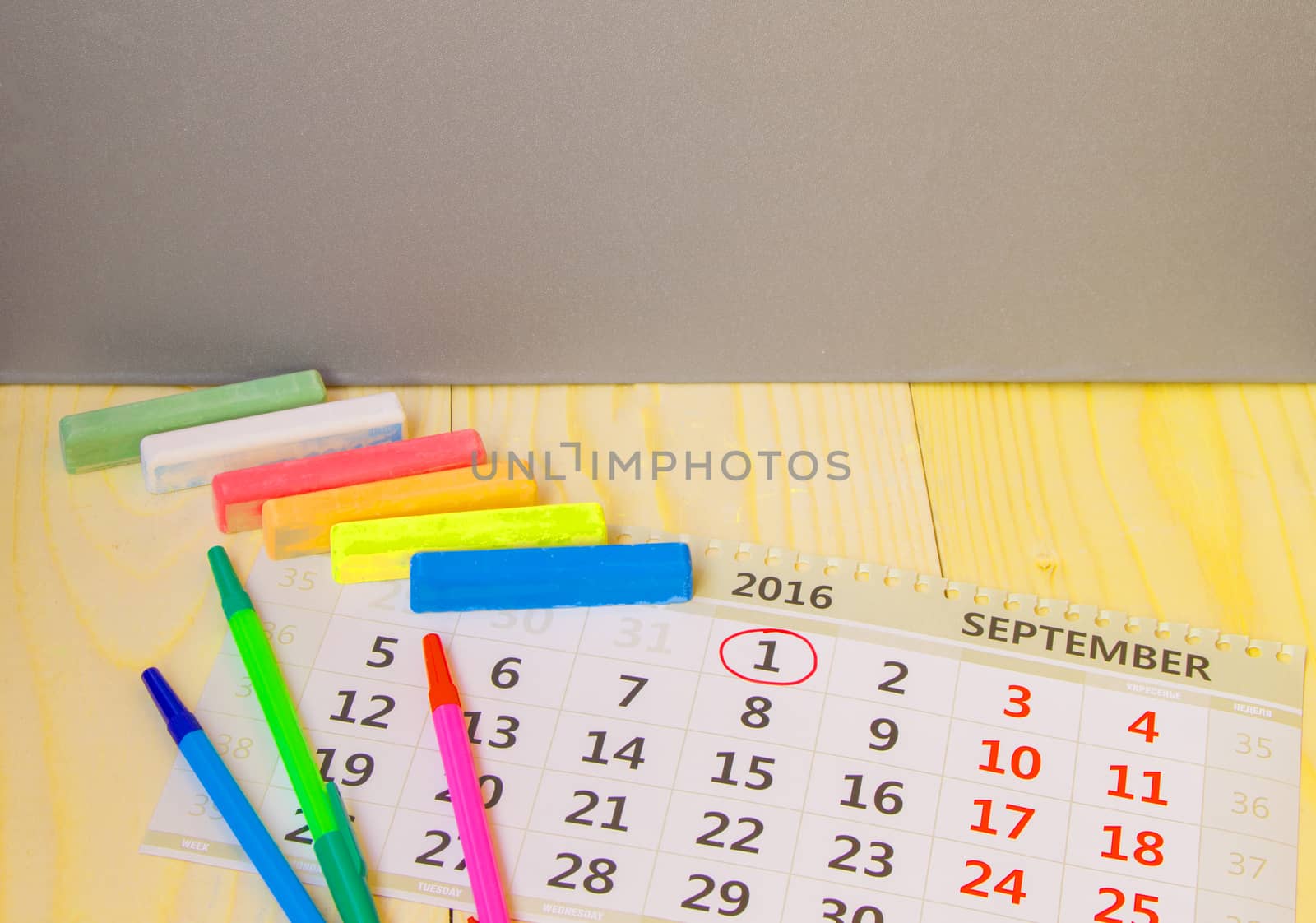 Back to school, calendar, colored chalk on wooden background.