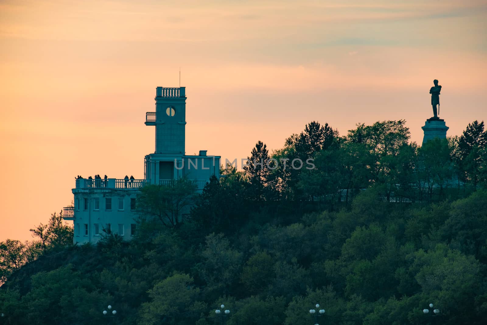 Sunset on the embankment of the Amur river in Khabarovsk. The sun set over the horizon. The embankment is lit by lanterns.