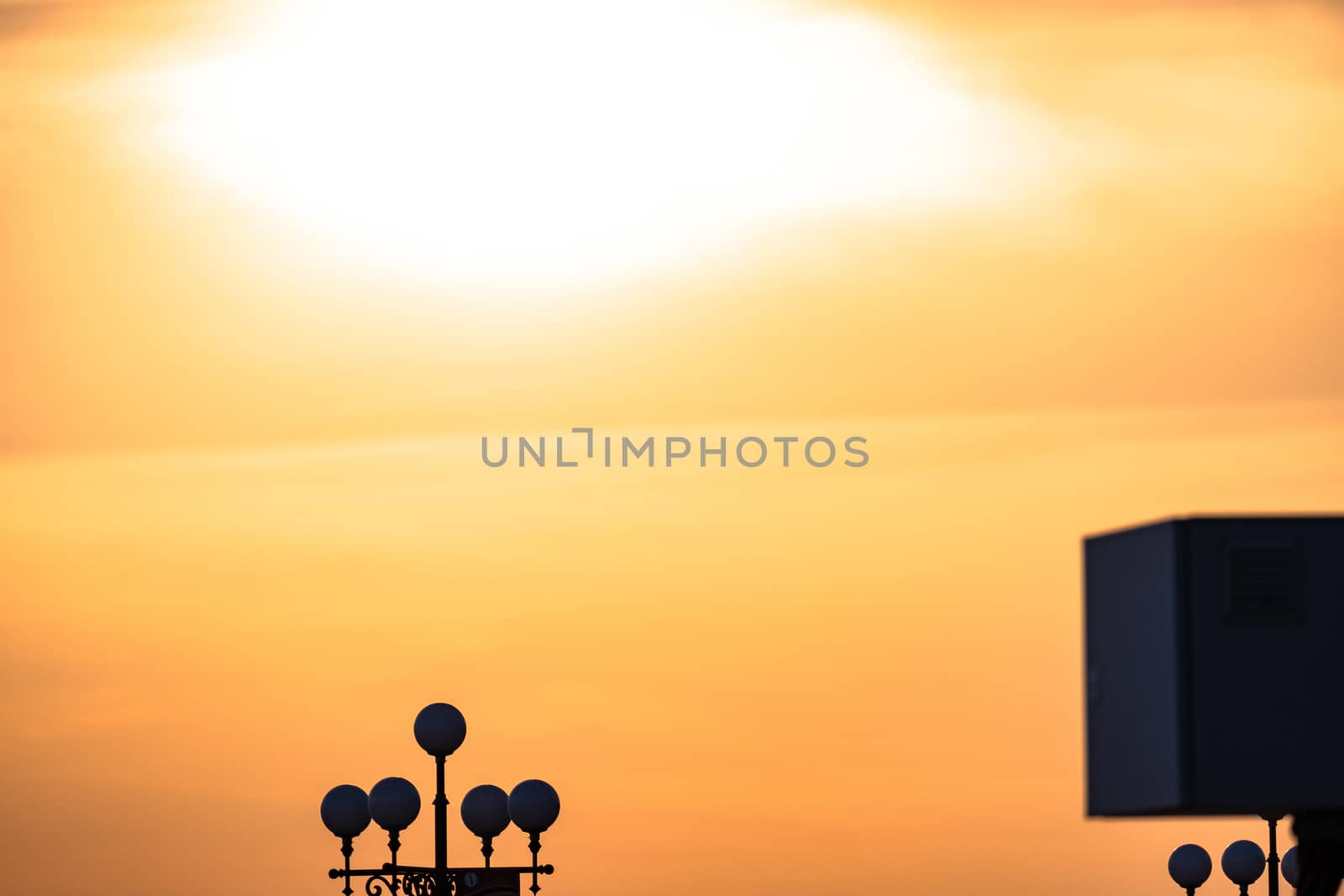 Sunset on the embankment of the Amur river in Khabarovsk. The sun set over the horizon. The embankment is lit by lanterns.