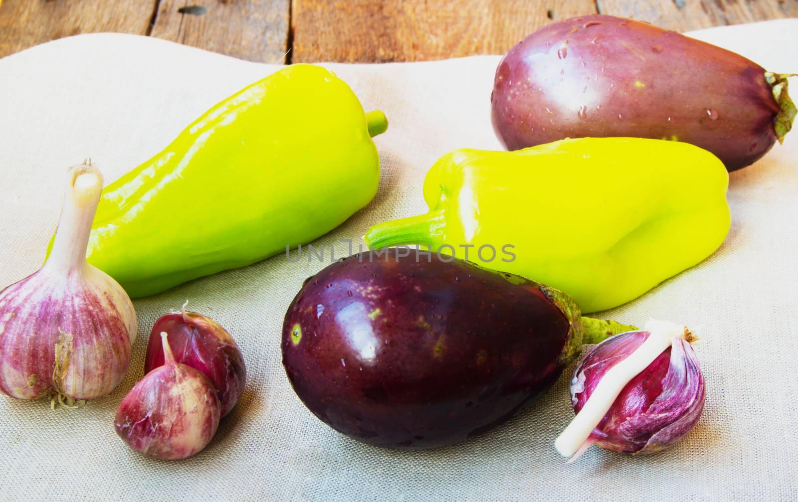 Raw eggplant, garlic, bell peppers, healthy eating and diet concept on the old wooden background by claire_lucia