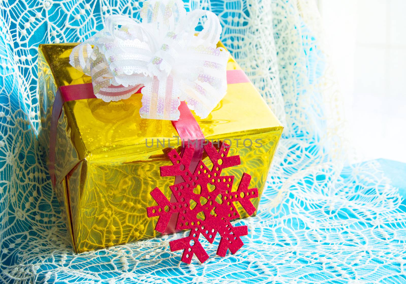 Gift box in gold foil package and red snowflake beautiful blue Christmas background, Christmas concept.