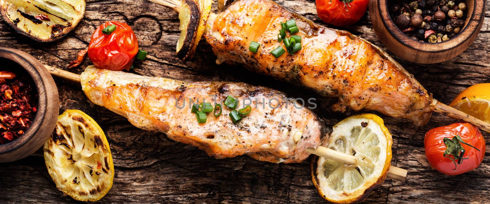 Grilled salmon with vegetables on wooden table.Grilled fish with spices