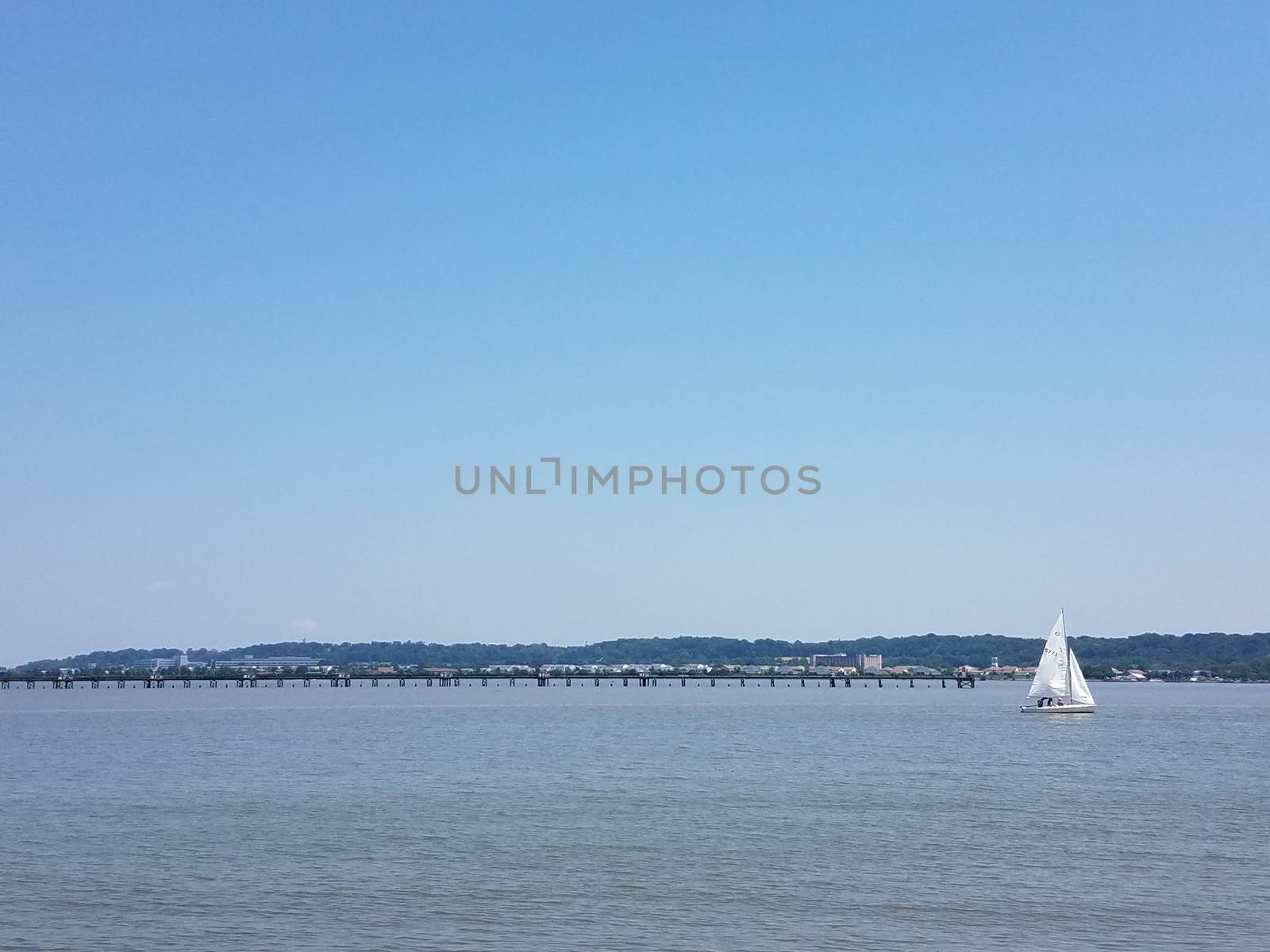 Potomac river water with sailboat and pier and Washington, DC in the background