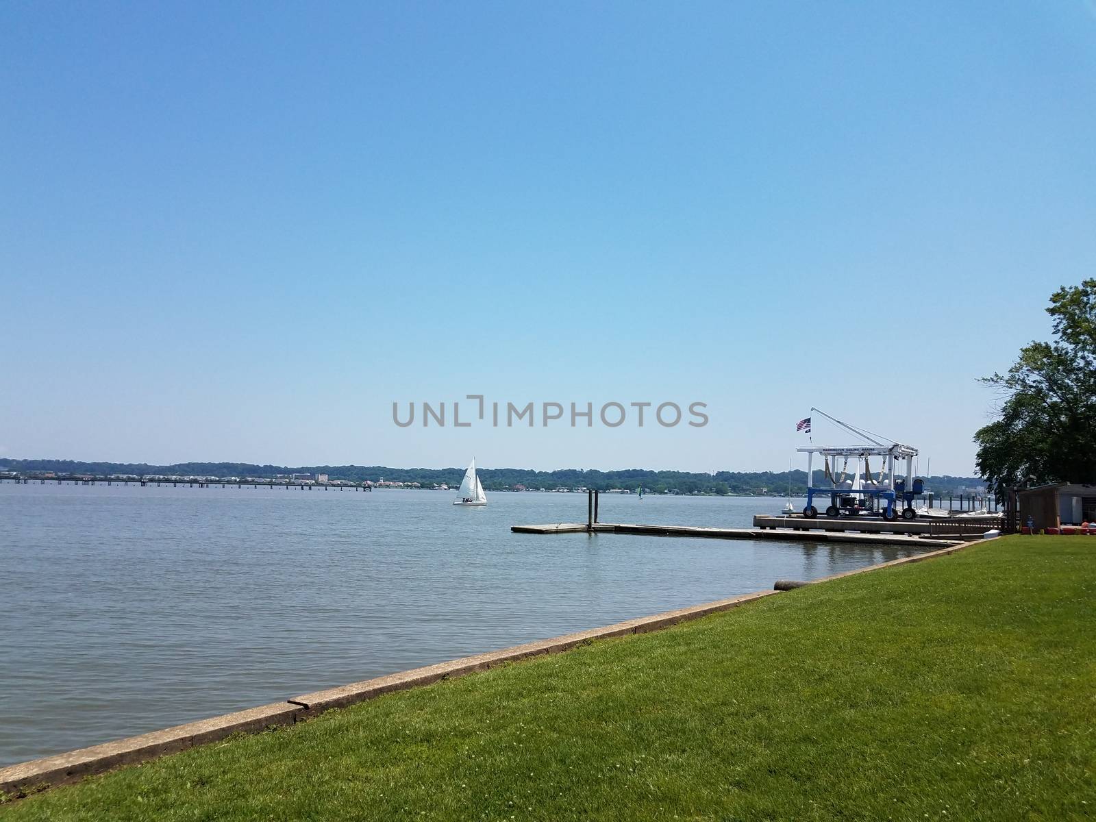 Potomac river with sailboat and pier and Washington, DC with boat lift or crane