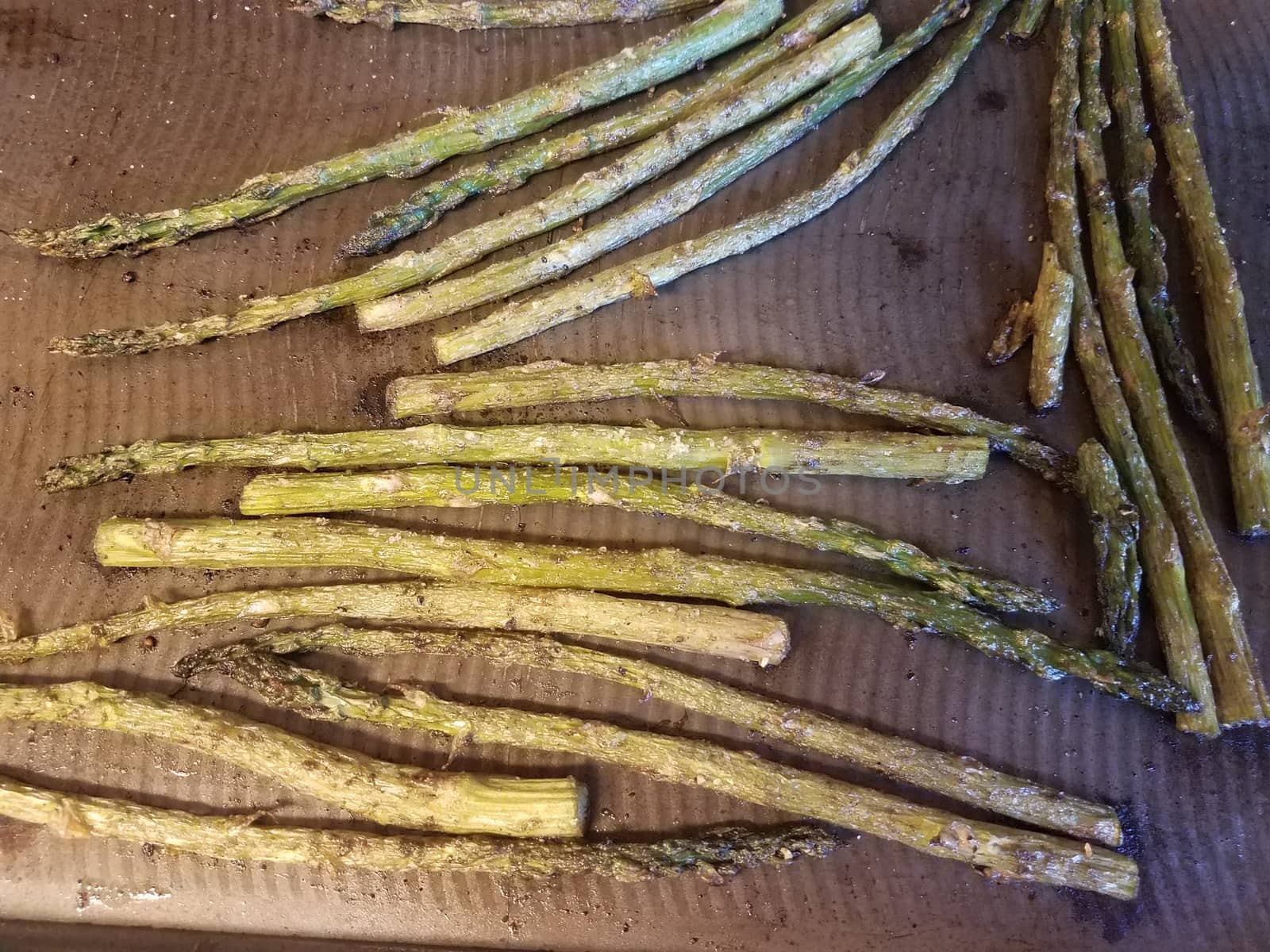 metal tray with seasoned baked green asparagus vegetables