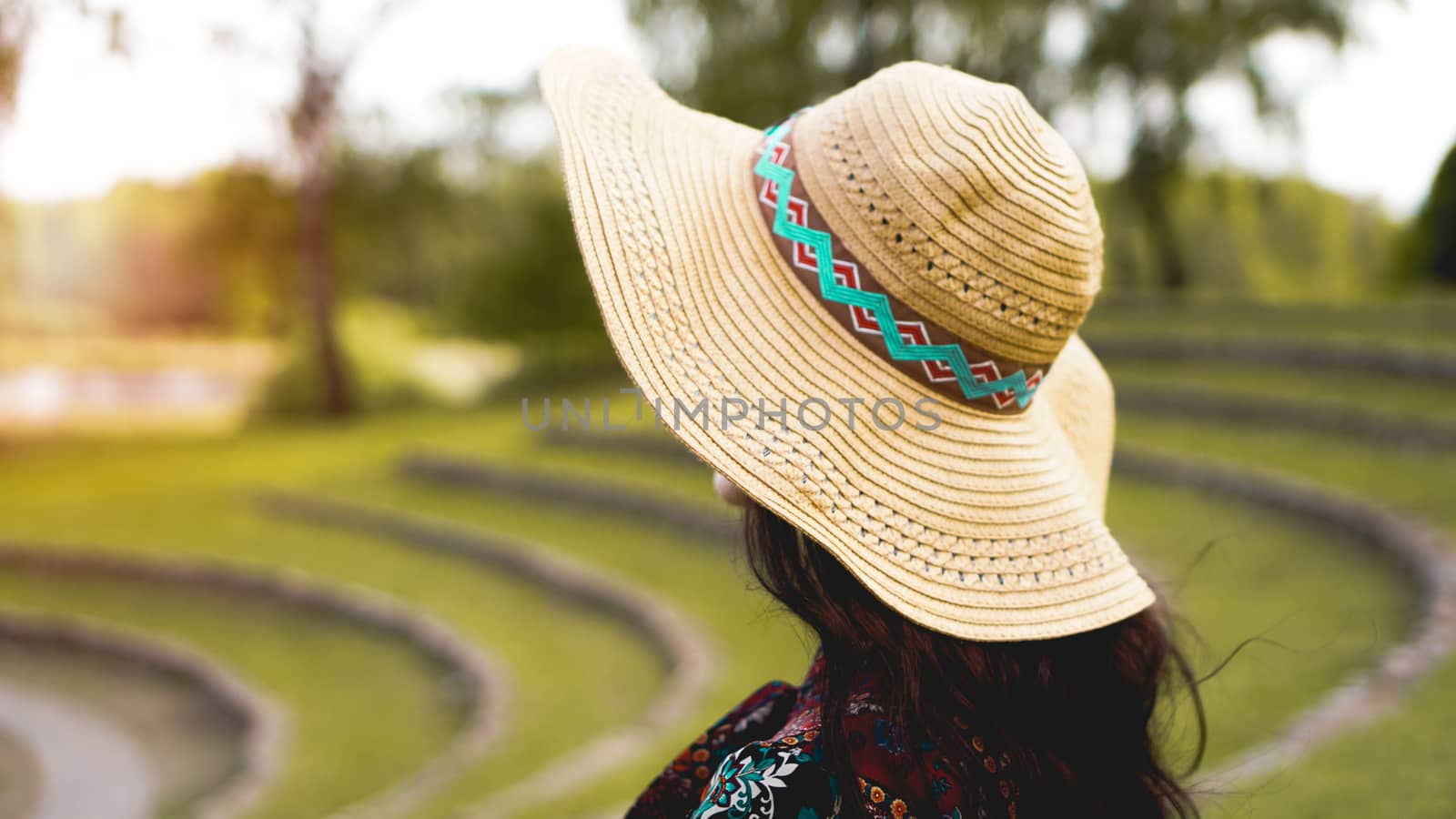 Beautiful young lady in shine through dress touch straw hat. Girl walk at hillside like rice farming