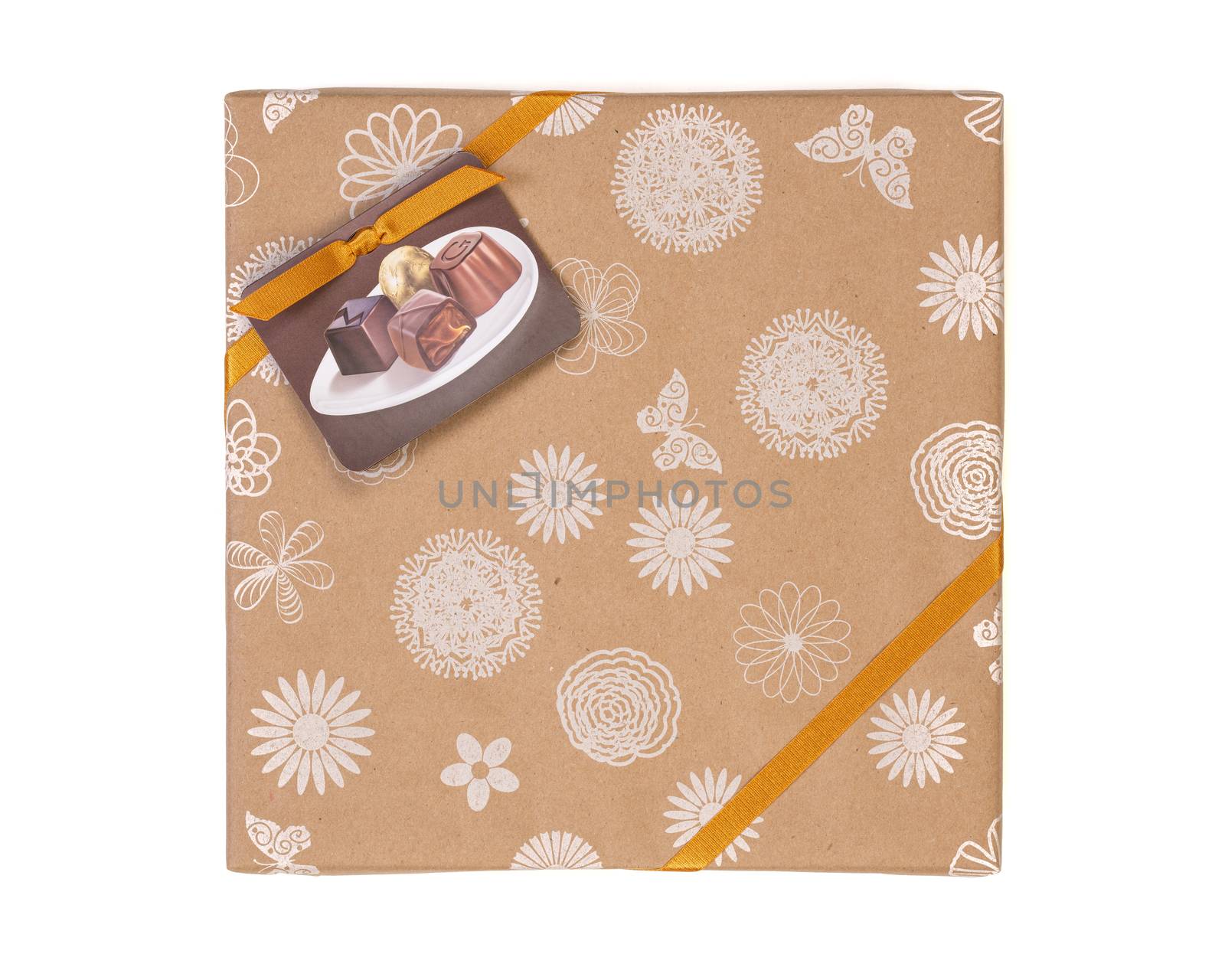 Gift wrapped box with chocolate candies and golden tape on a white background.