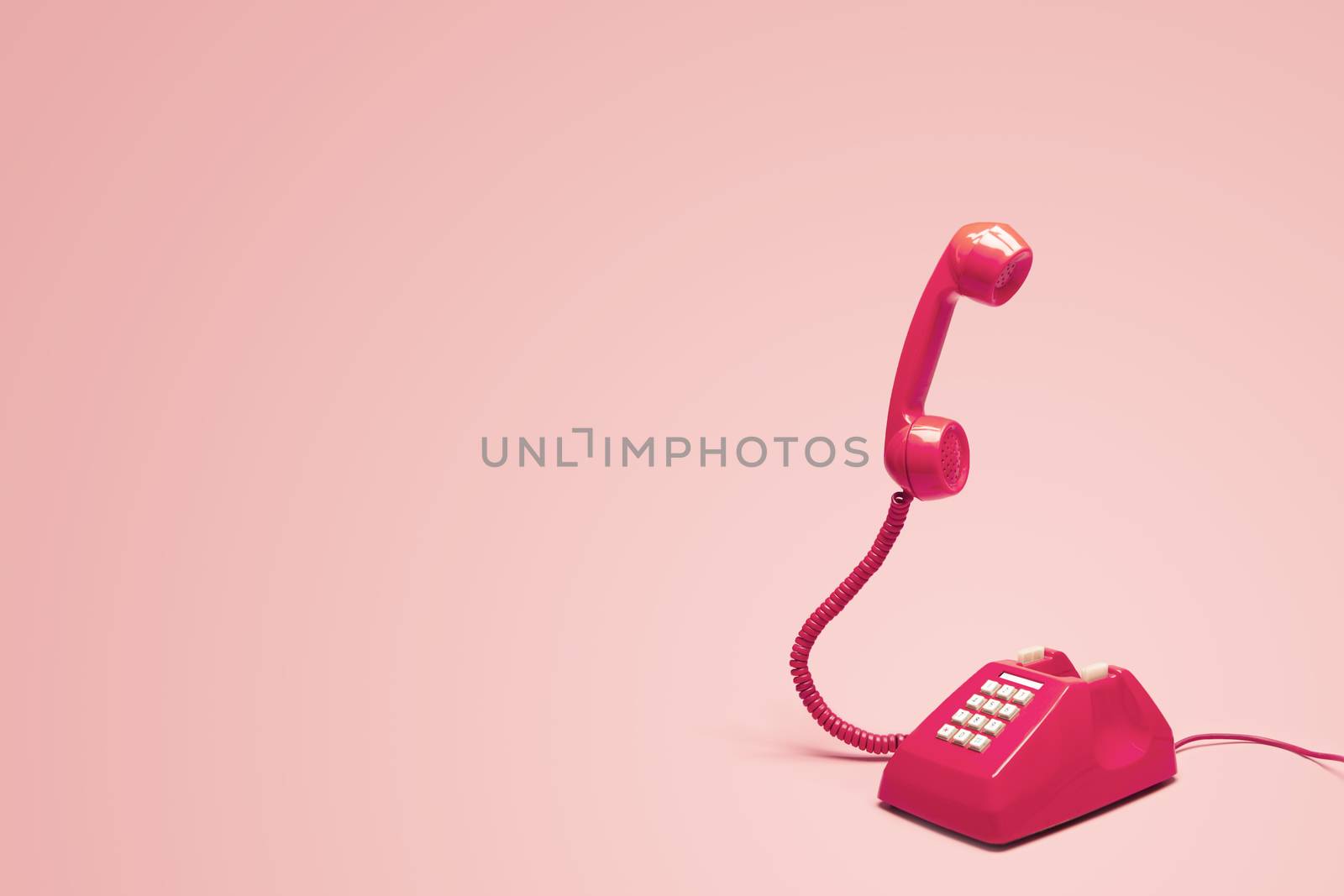 Retro pink telephone on retro pink background by zendograph