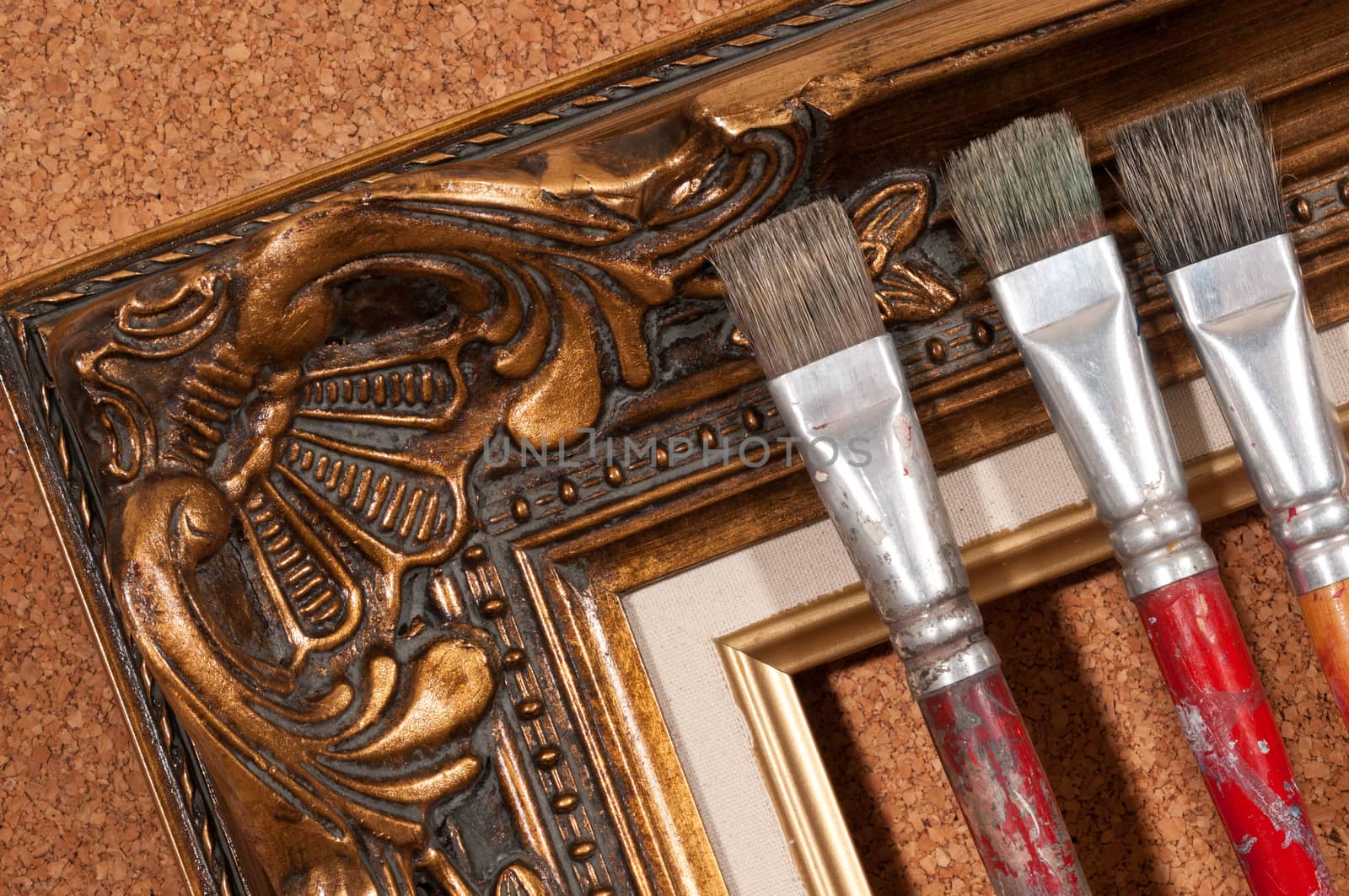 Paint brushes and wood picture frame.