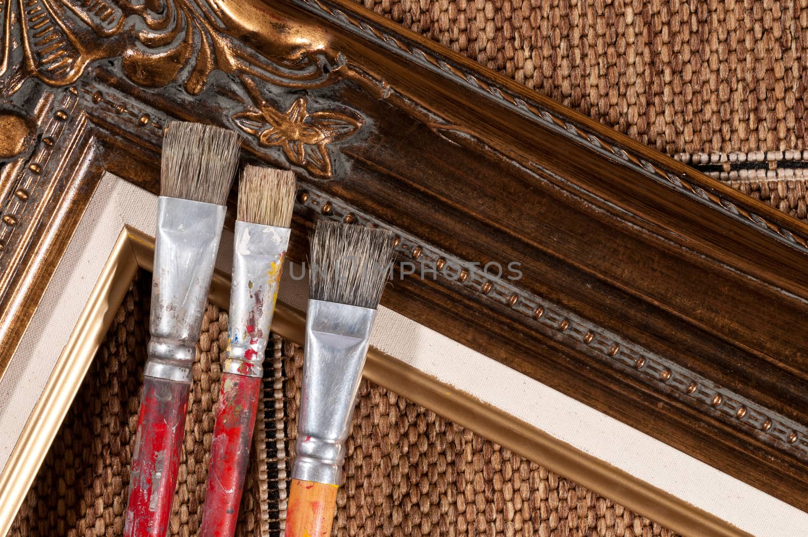 Paint brushes and wood picture frame.