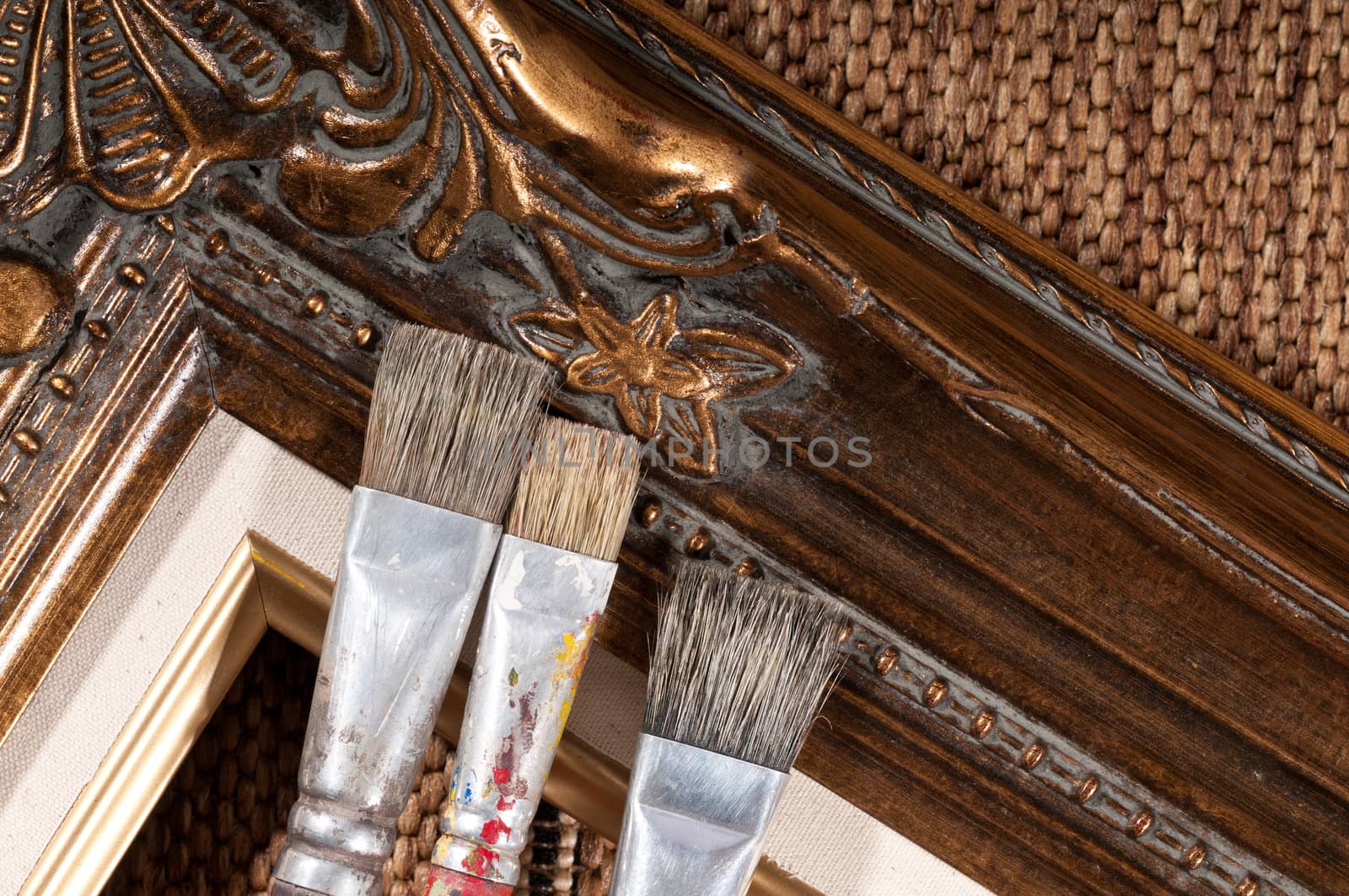 Paint brushes and wood picture frame.