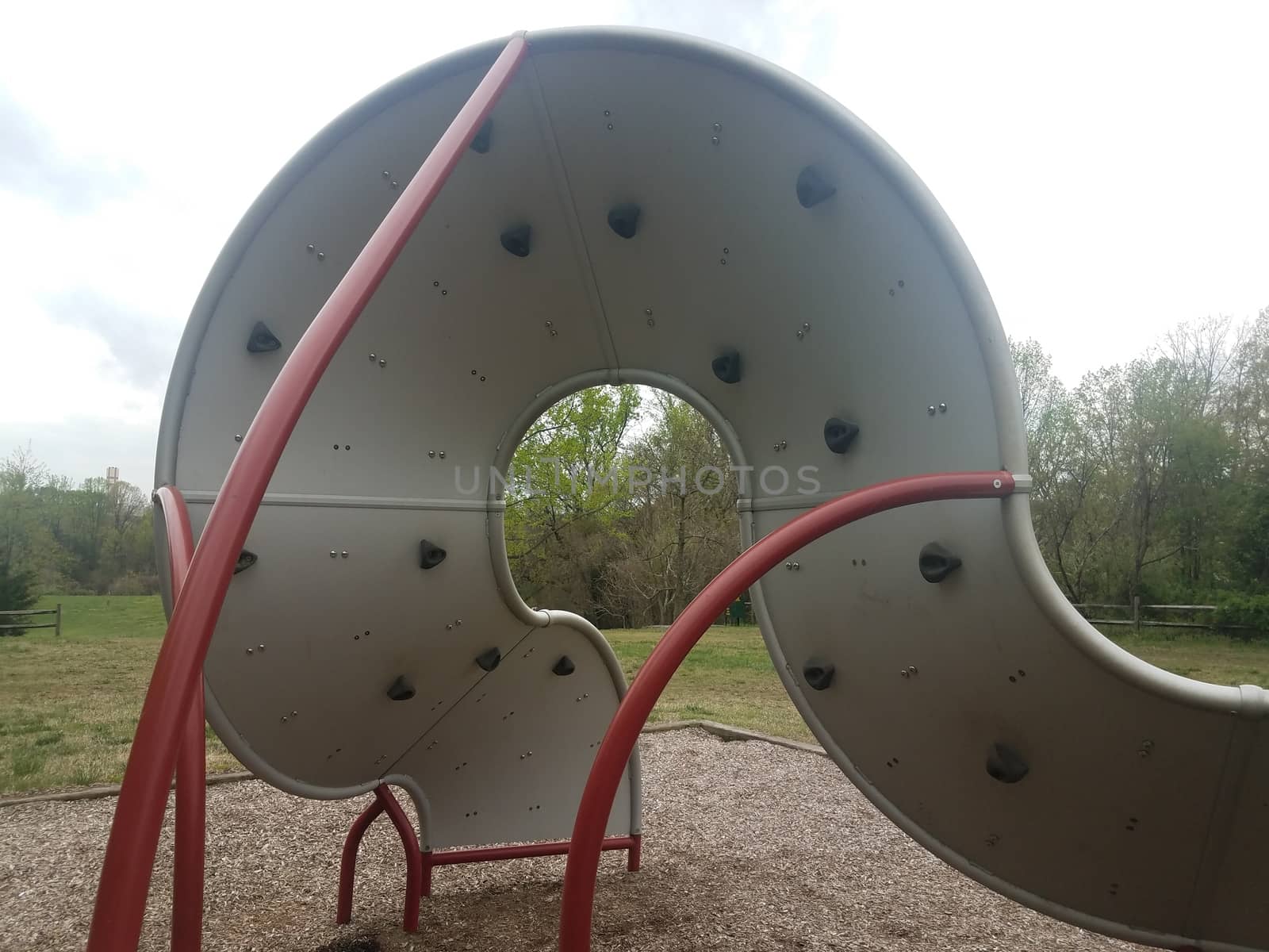 curved playground climbing structure wall with hand and foot holds by stockphotofan1