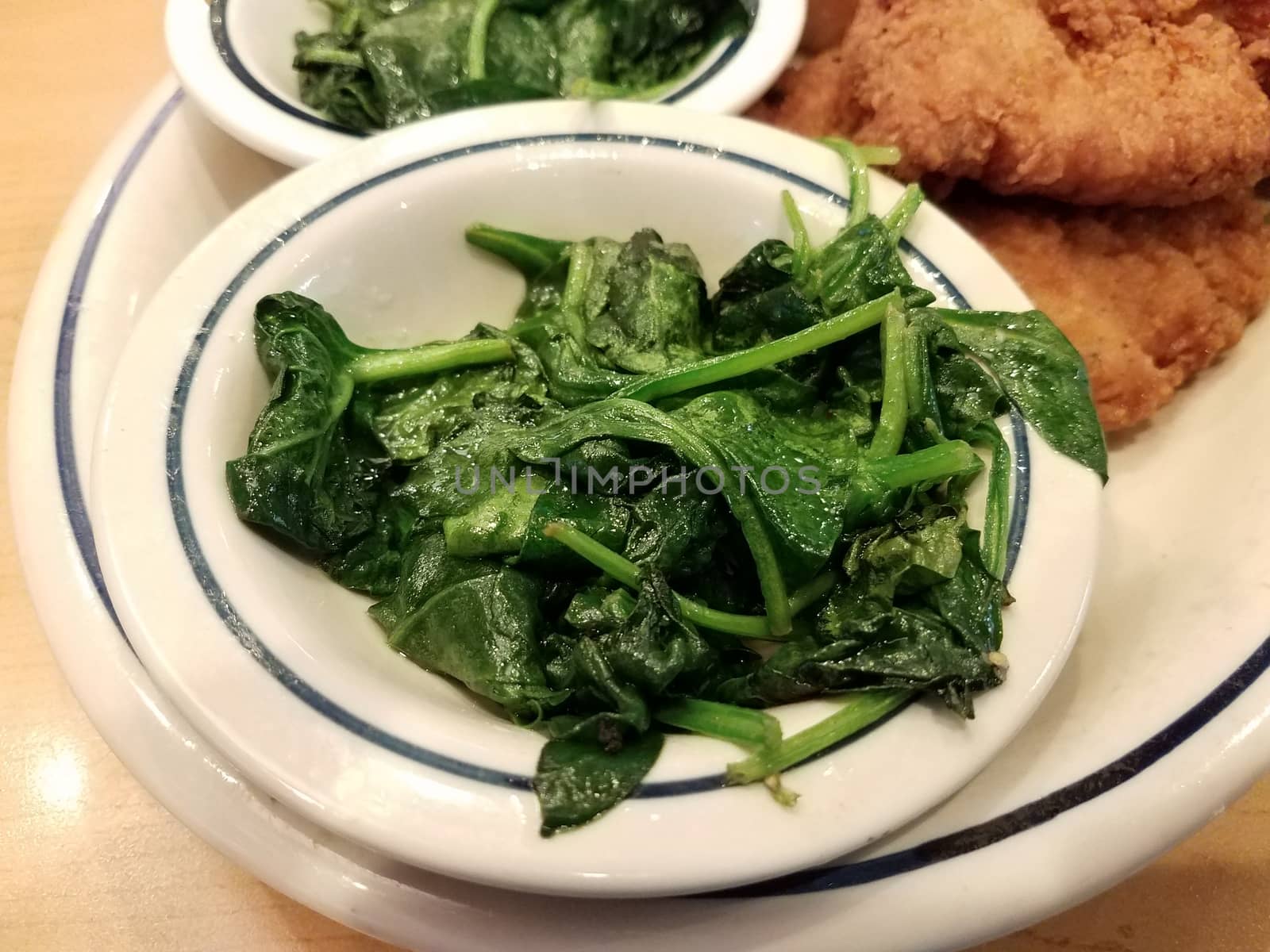green spinach side dish in bowl with fried chicken