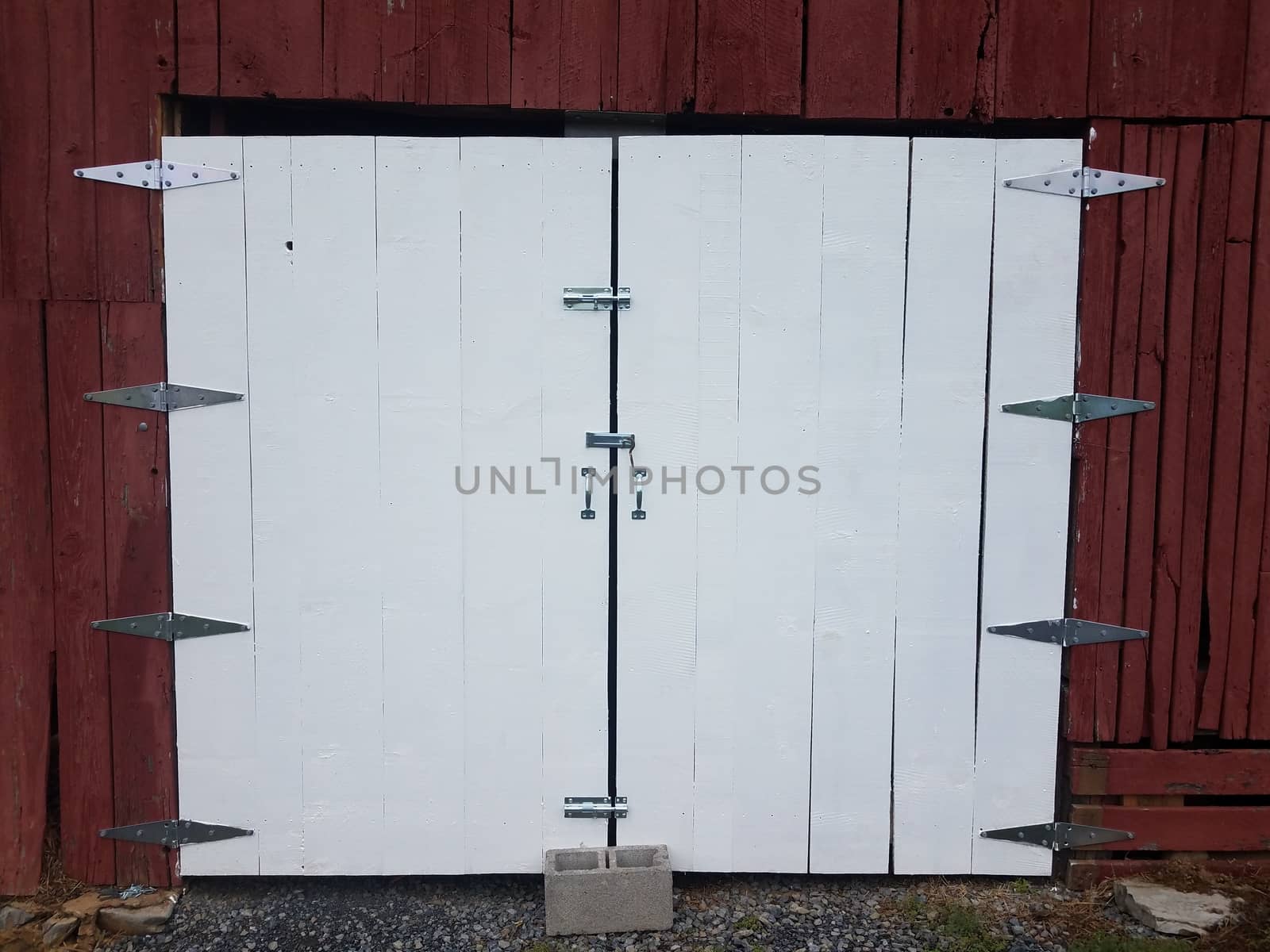 red wood barn or building with white closed doors