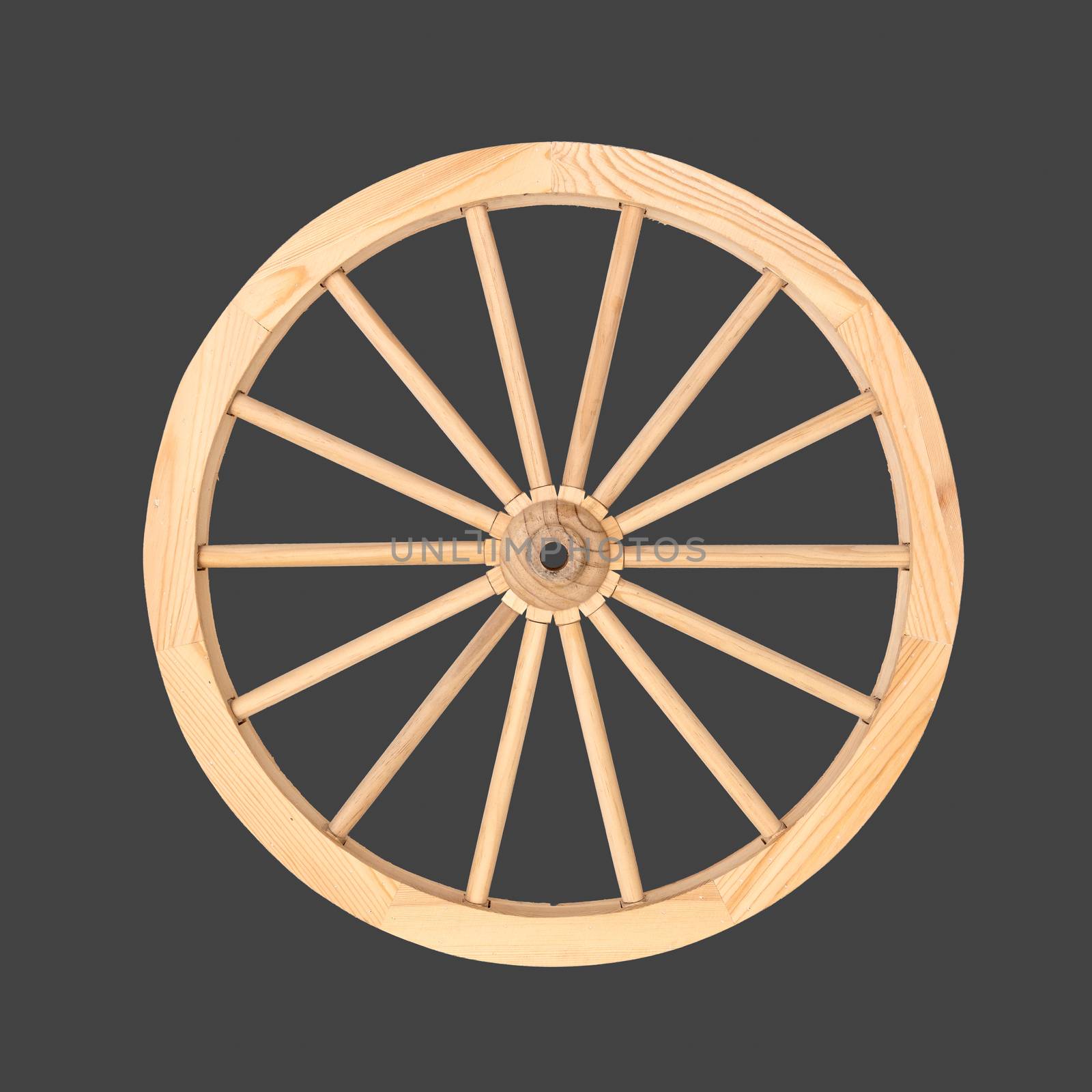 Clean wooden wheel from a cart used for decoration purposes isolated on a gray background.