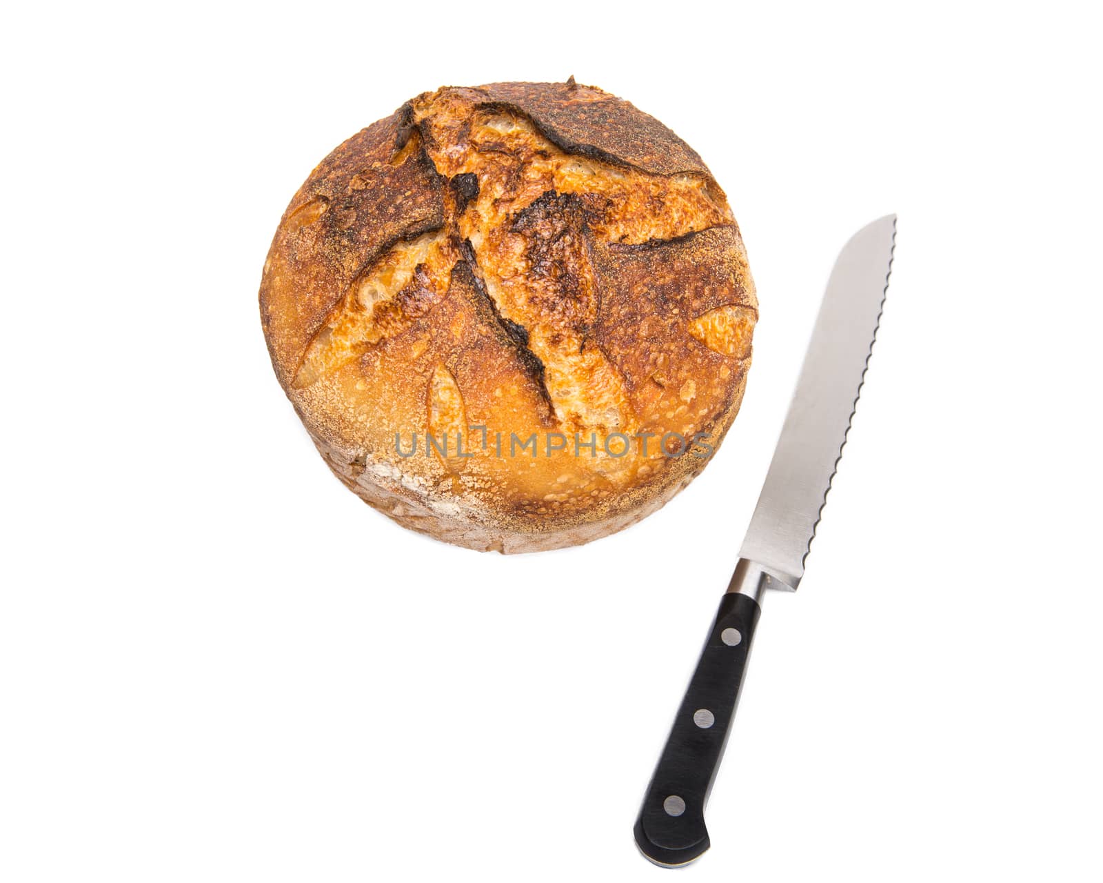 A fresh loaf of round artisan sourdough bread with a breaqd knife.