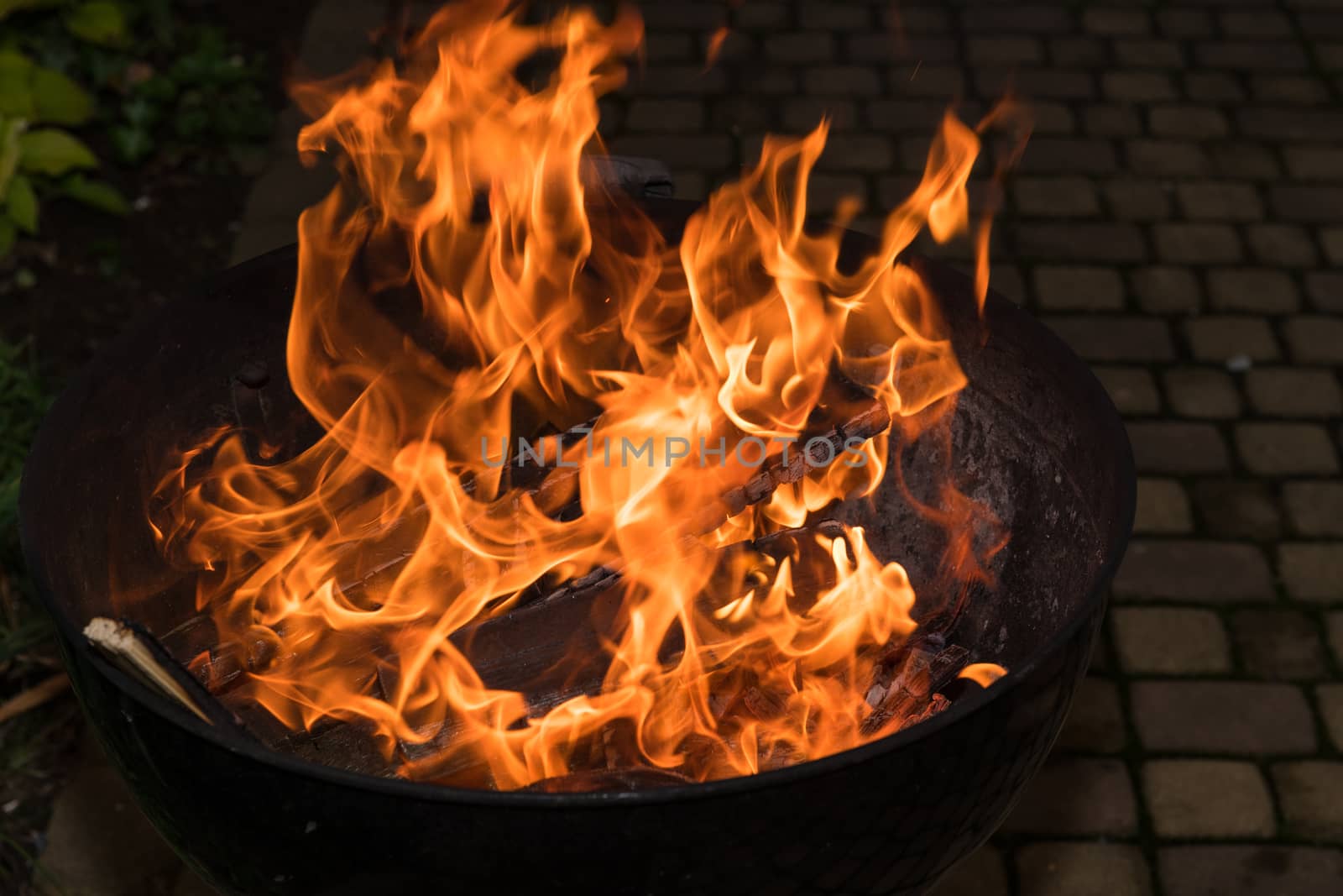 Close-up of blazing fire in BBQ grill at evening.