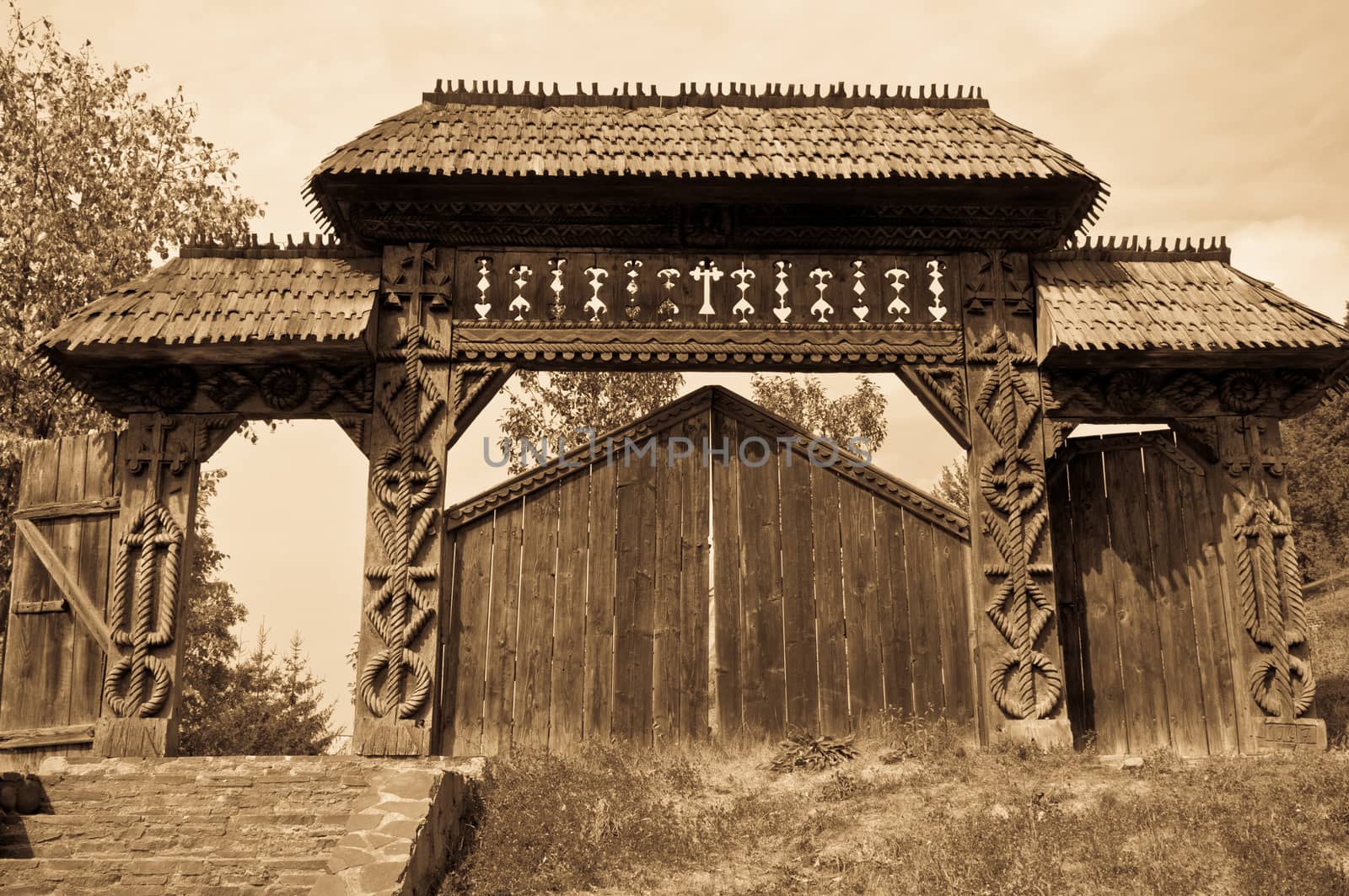 Traditional carved wooden gate from Maramures region, Romania, sepia tones.
