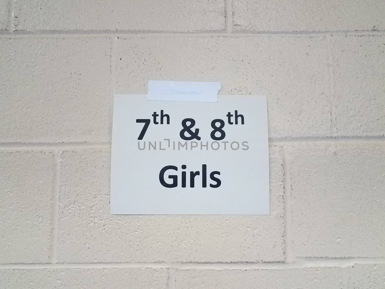 paper 7th and 8th girls sign on white cement wall by stockphotofan1