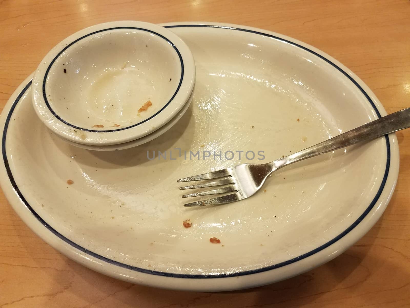 empty dirty bowl and plate with fork on wood table by stockphotofan1