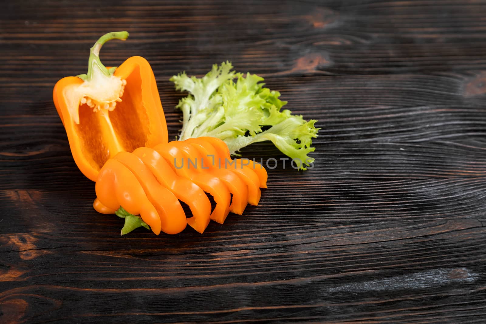 Paprika of orange color cutting on a wooden chopping board