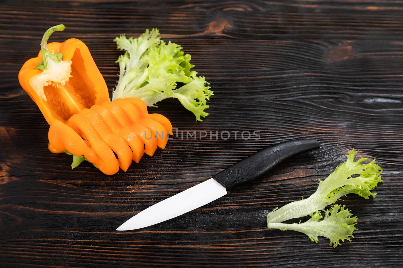 Paprika of orange color cutting on a wooden chopping board