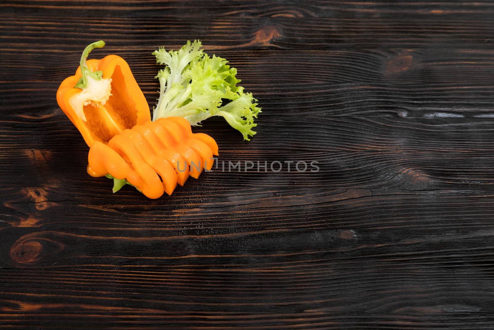 Paprika of orange color cutting on a wooden chopping board