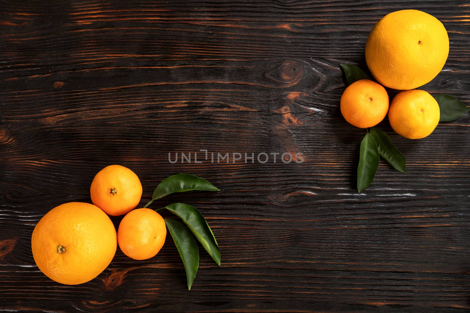 top view of whole ripe tangerines scattered on wooden chopping board