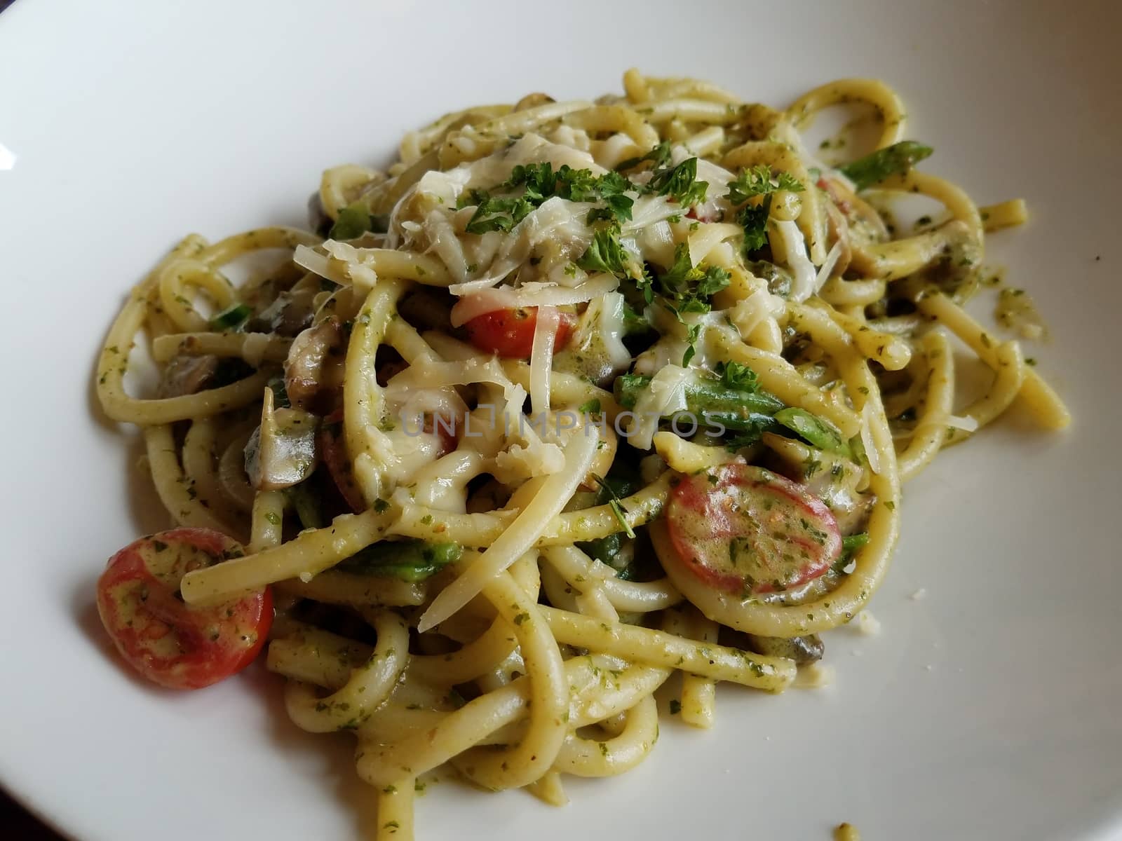 Italian pasta with cheese and tomato on white plate