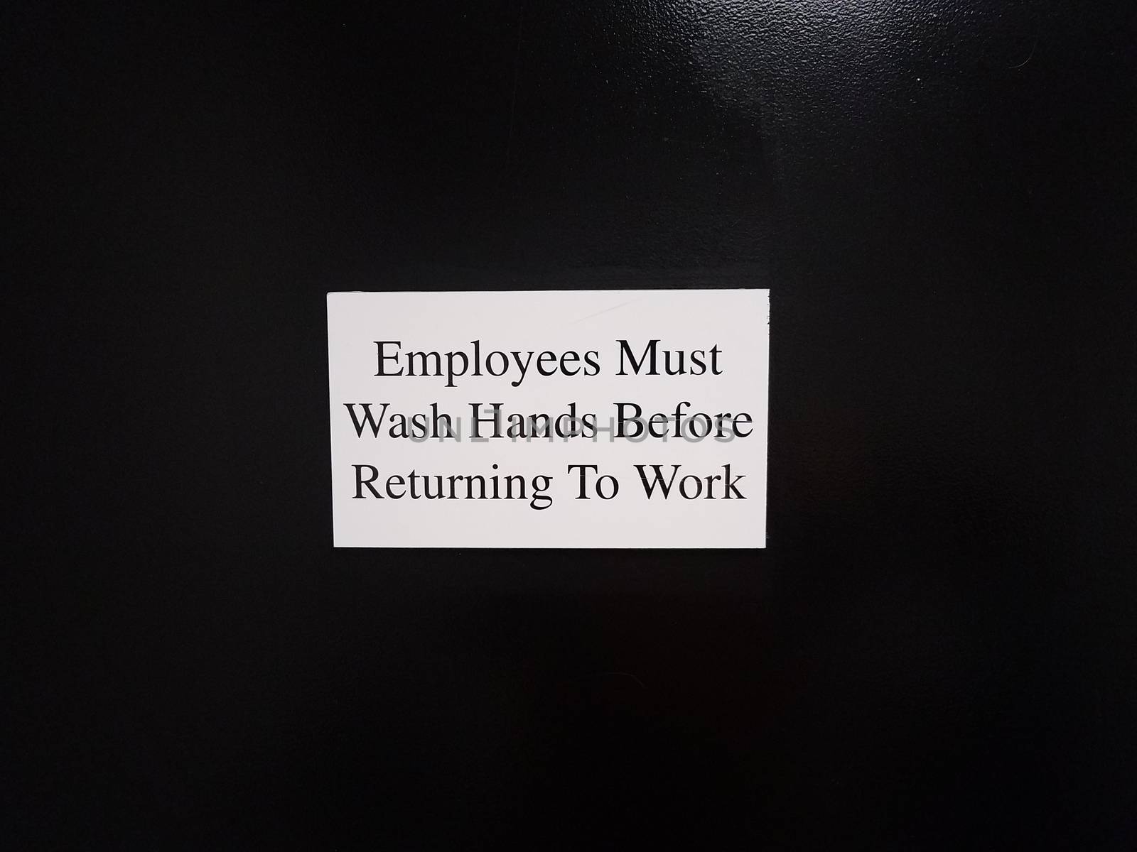 employees must wash hands before returning to work on black wall by stockphotofan1