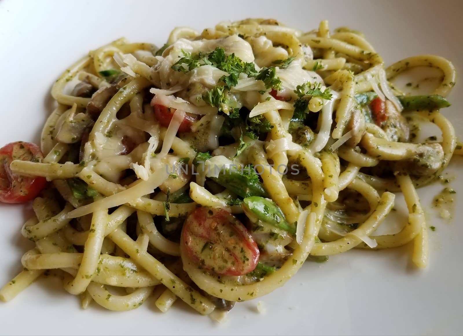 Italian pasta with cheese and tomato on white plate