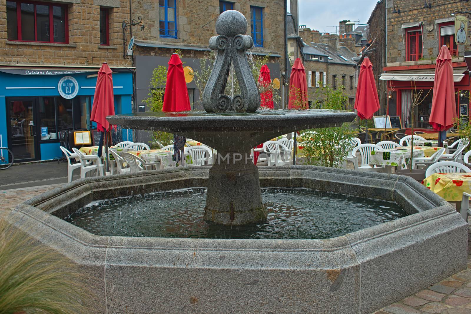 AVRANCHES, FRANCE - April 4th 2019 - Fountain at main square with restaurants around