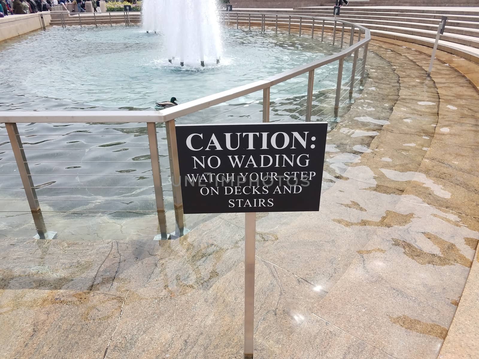 caution no wading watch your step on decks and stairs sign and fountain by stockphotofan1