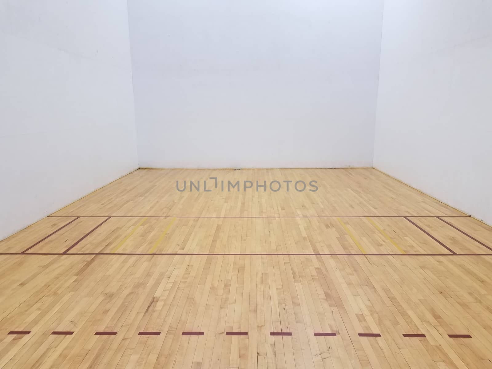 wood floor on racketball court with white walls