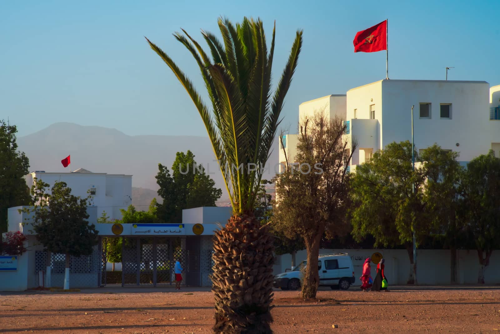 Agadir university Ibn Zohr entrance with Moroccan flag mountains and trees