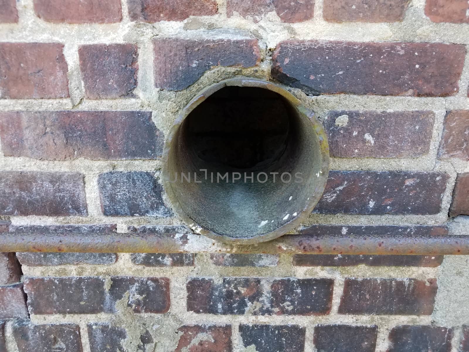 metal pipe or tube in red brick wall by stockphotofan1