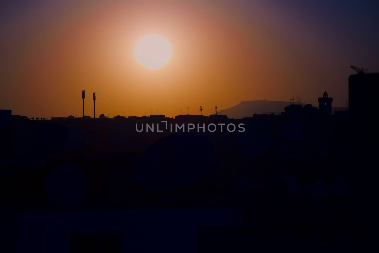 sunset on the city of Agadir Morocco with antennas minaret and hill Oufella