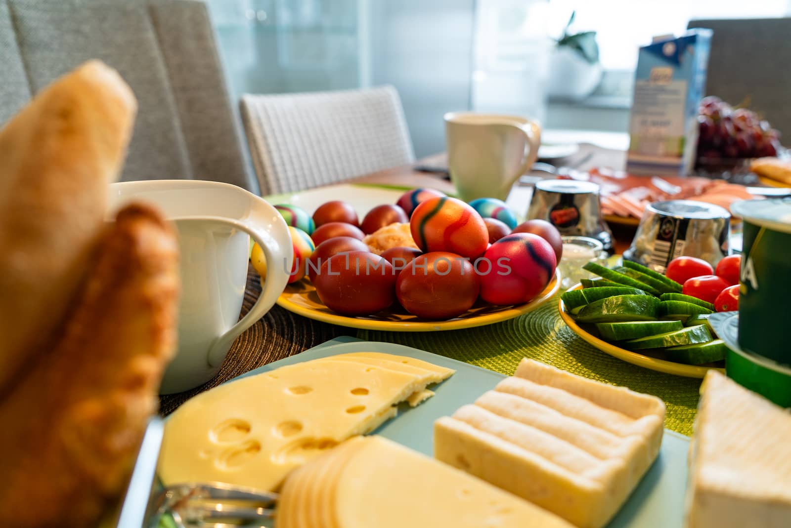 Colored eggs as a traditional symbol of Easter celebration on a breakfast table in Germany together with other toppings.