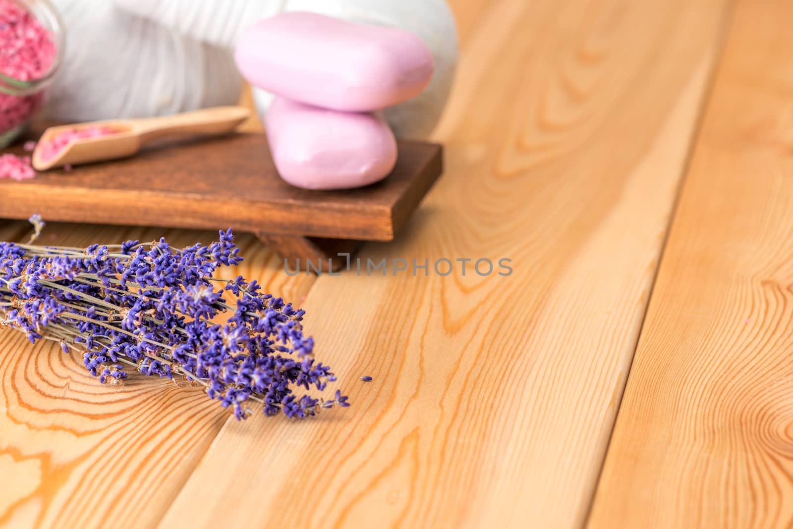 dried lavender and soap with natural lavender extract for spa treatments and relaxation on wooden boards close-up
