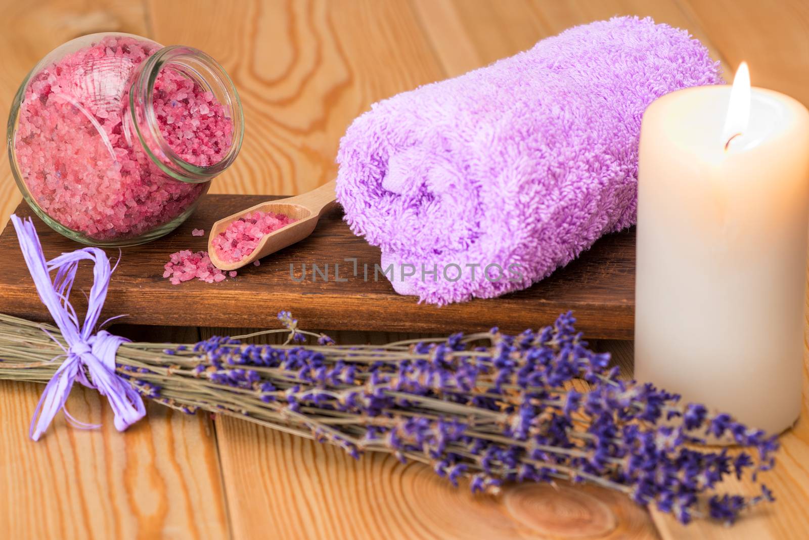 burning candle, towel and sea salt with lavender close-up objects for spa treatment