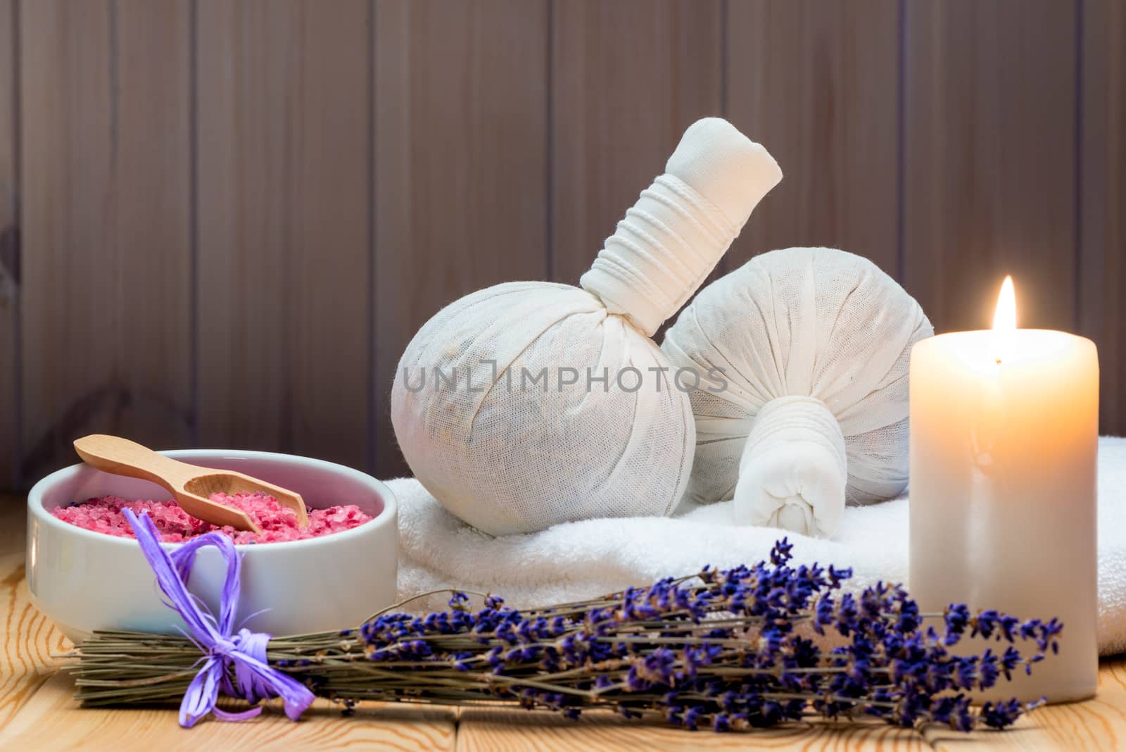 herbal bags with natural lavender and sea salt with a burning candle for a spa, relaxation and romantic atmosphere