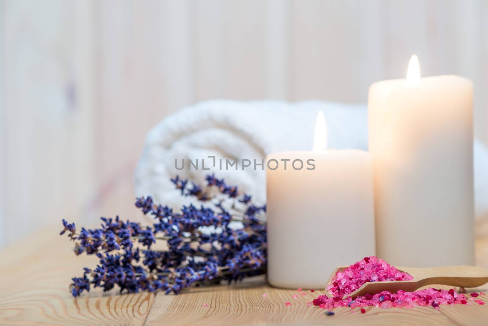 closeup of sea salt with lavender and burning candles spa proced by kosmsos111