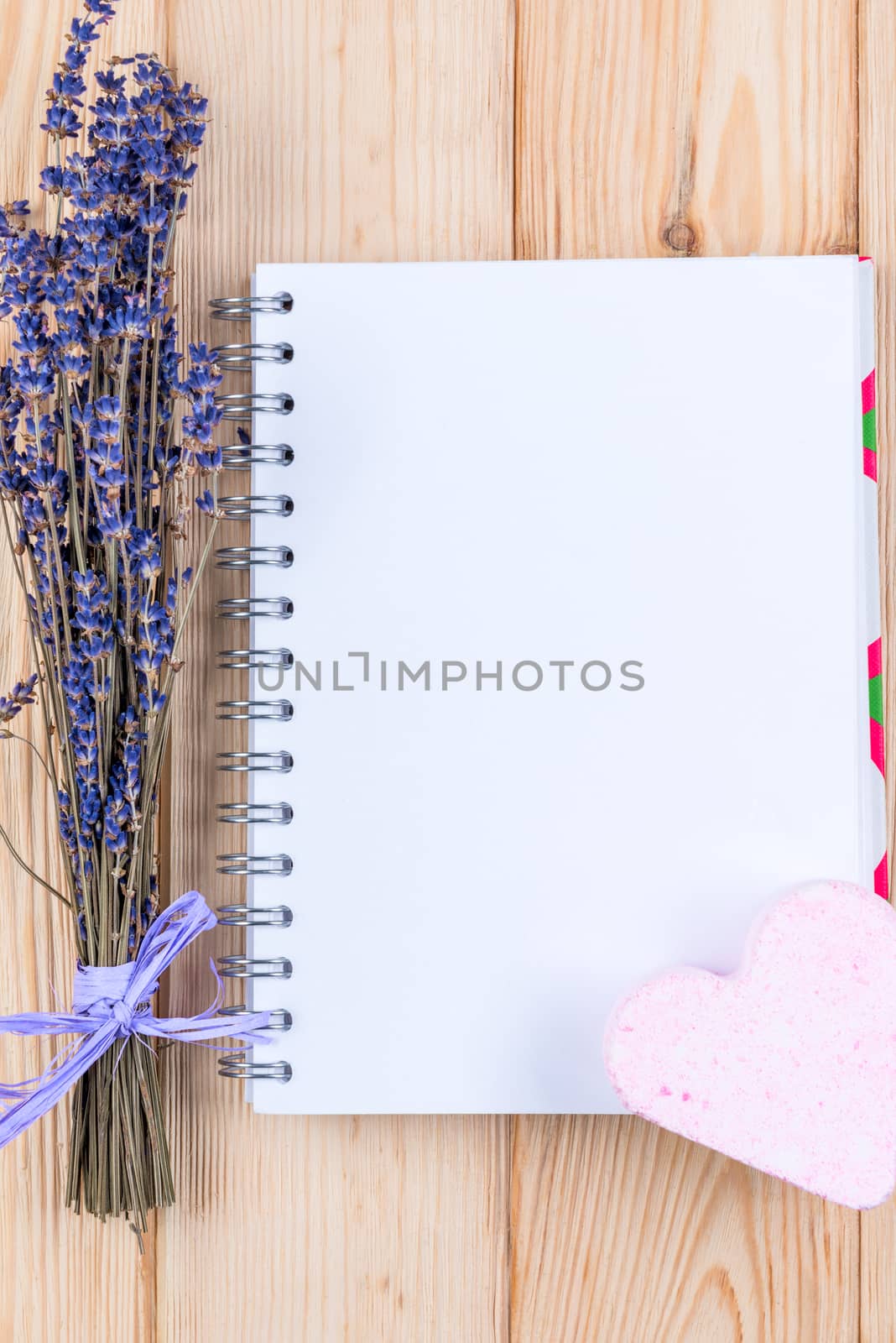 blank sheet of notebook for the inscription and a bunch of lavender flowers top view