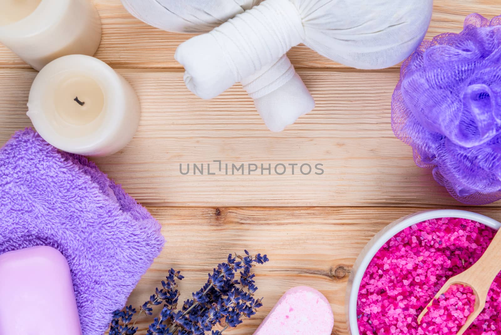 on wooden boards, herbal massage bags with lavender, cosmetic products for bath and spa